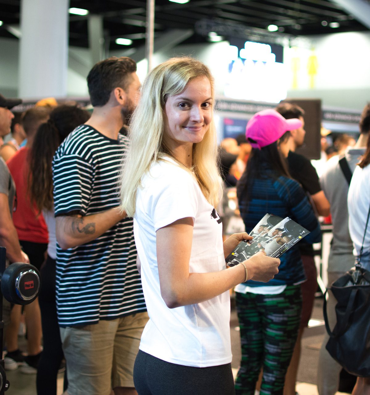 A smiling brand ambassador distributing flyers to people attending an event