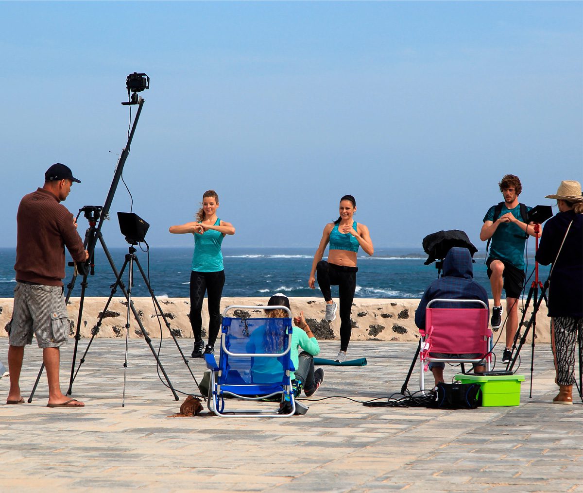 Promotional models conducting a demonstration on the beach in front of a camera crew