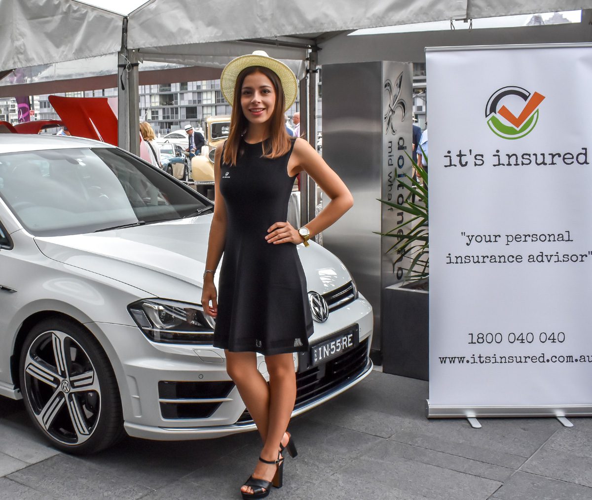 A promotional model posing with a white car